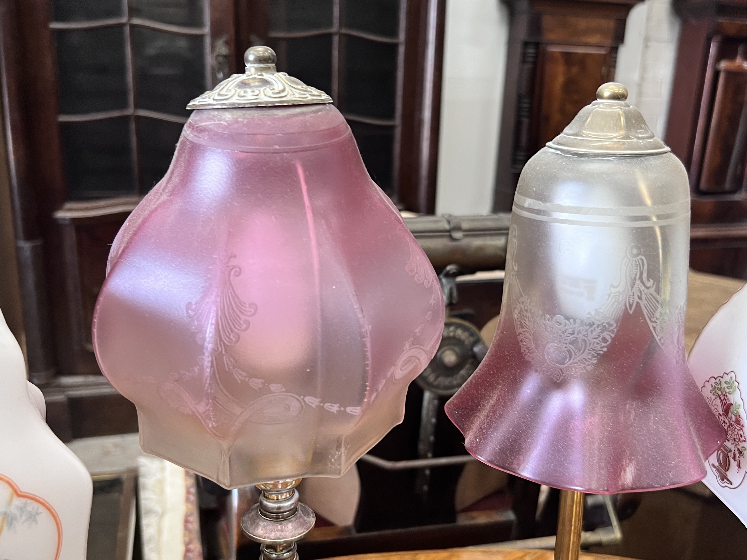 Two Edwardian silver plated and brass table lamps with etched cranberry shades and two converted candlestick lamps, tallest 50cm